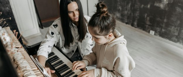A piano teacher and student at the keyboard during a lesson at Time Music Studios